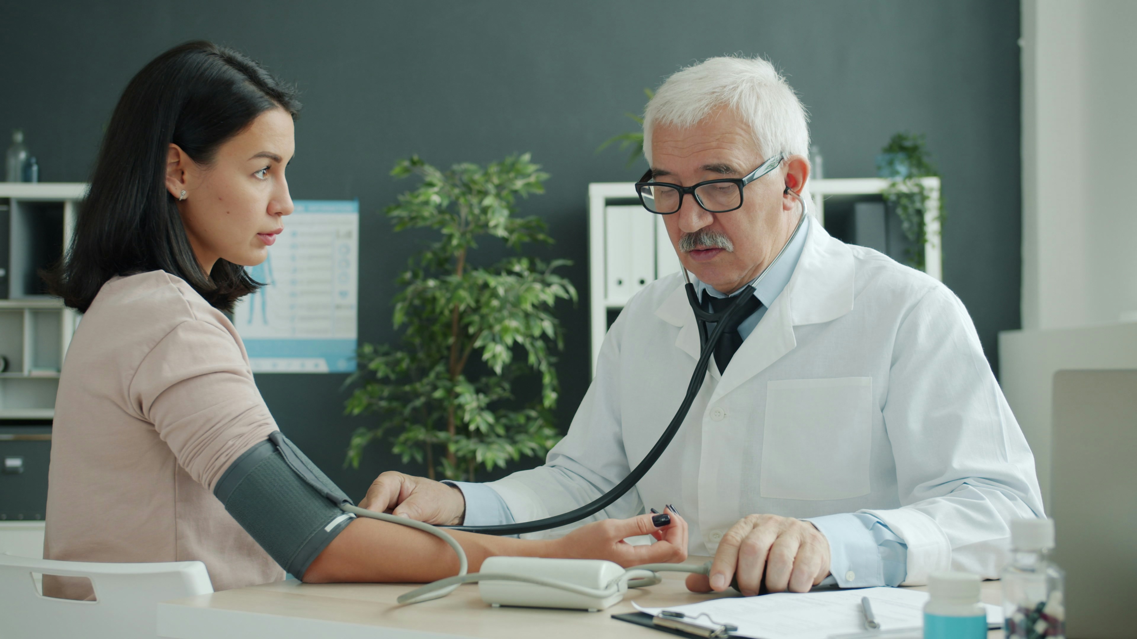 Atendimento de saúde ocupacional com profissional revisando exames e prontuarios.